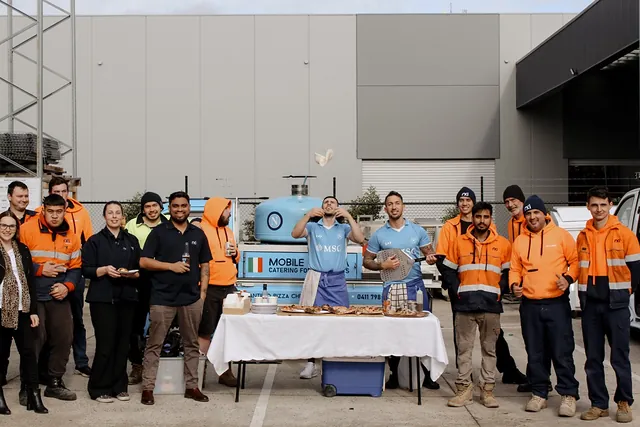 Workplace team in hi-vis lined up with the Antimo Pizza Chef truck