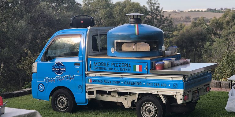 Antimo Pizza Chef truck with its blue wood-fired oven at a Melbourne event