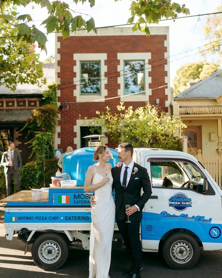 Bride and groom with the blue Antimo Pizza Chef truck on their wedding day
