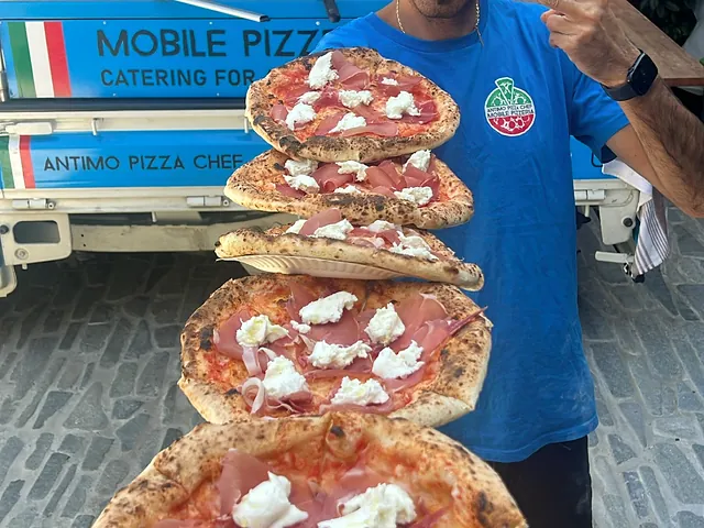 Stack of fresh wood-fired pizzas ready to serve